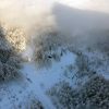 Erjavčeva's mountain hut in foggy sun flares from above
